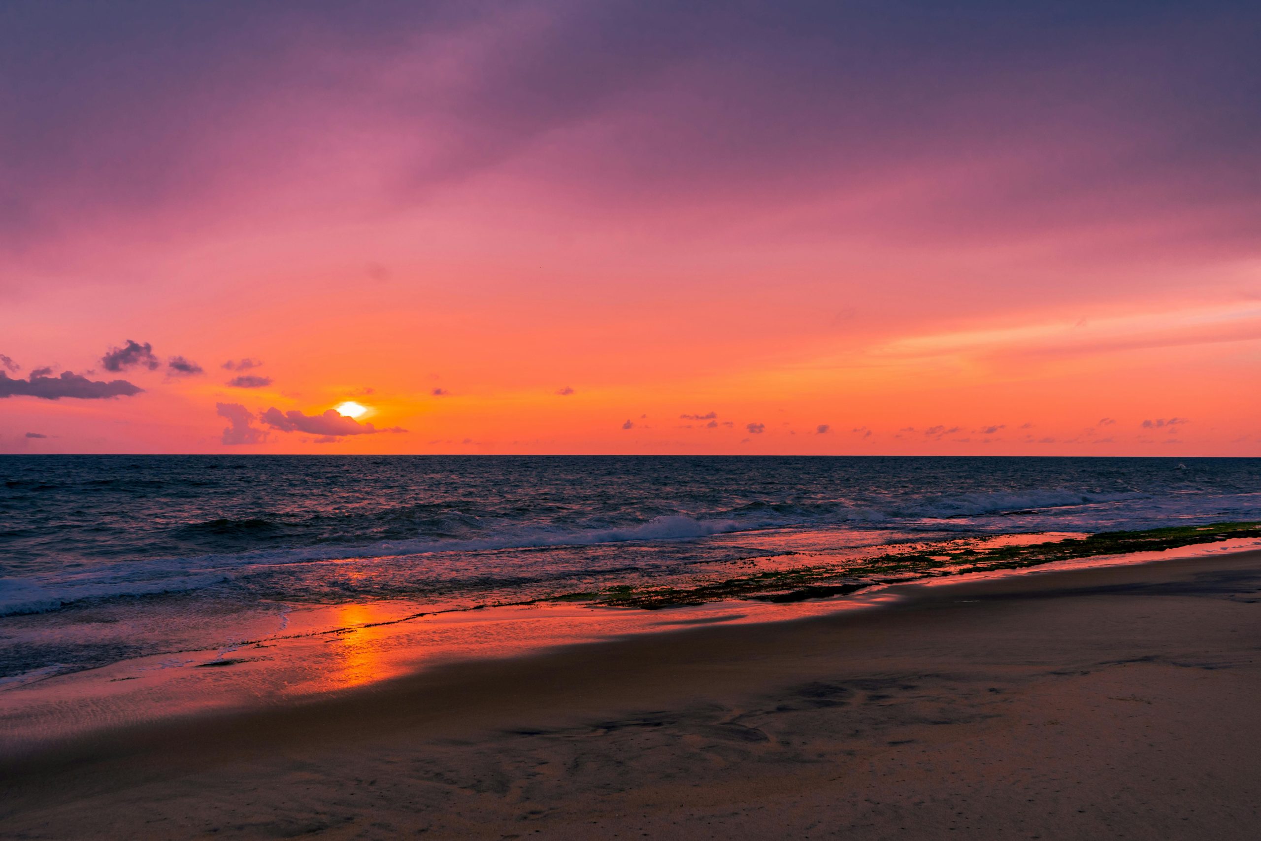 Vibrant sunset over Negombo Beach in Sri Lanka, capturing vivid ocean and sky colors.