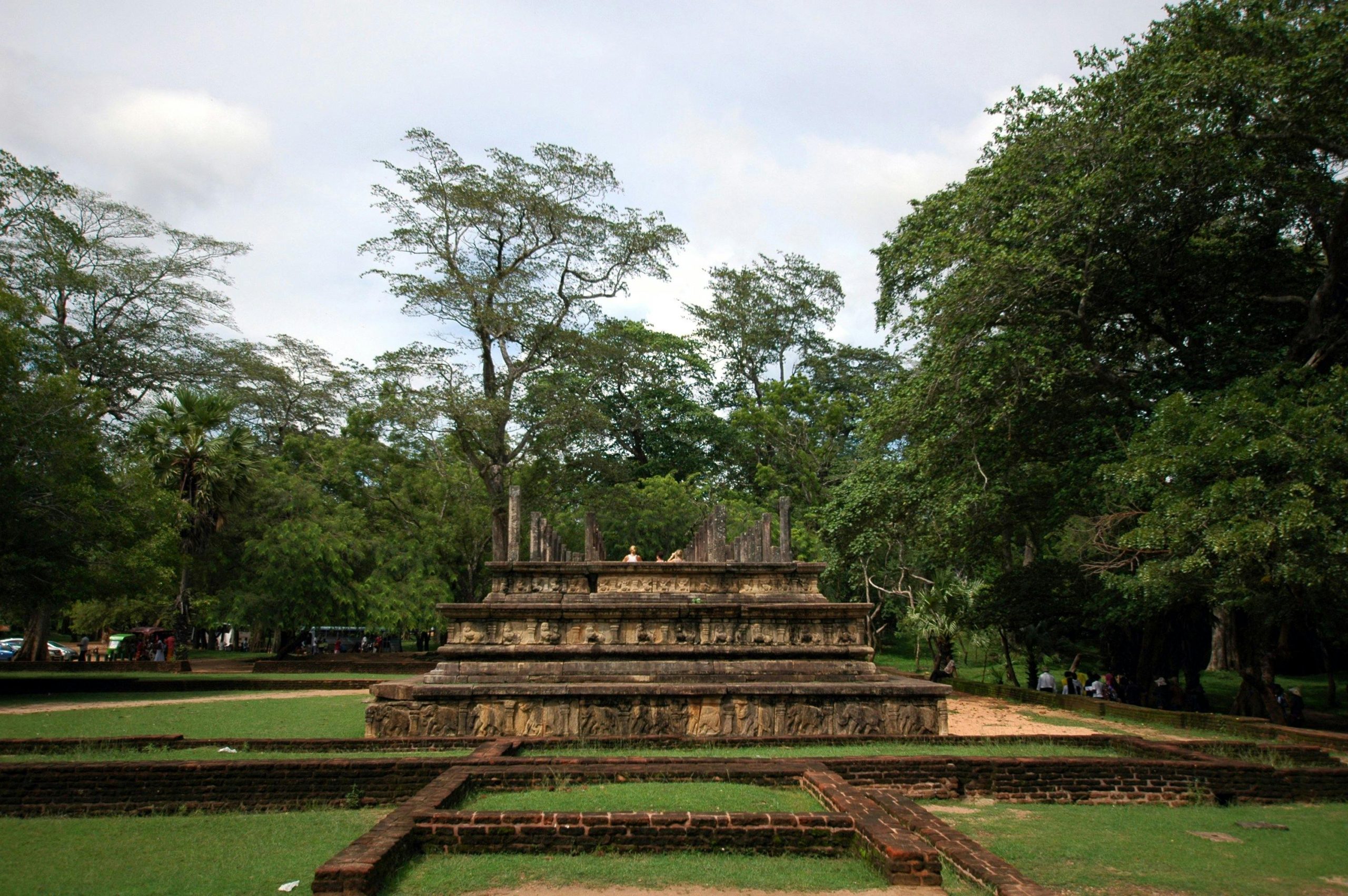 Serene view of ancient stone structure in lush green park, Central Province, Sri Lanka.